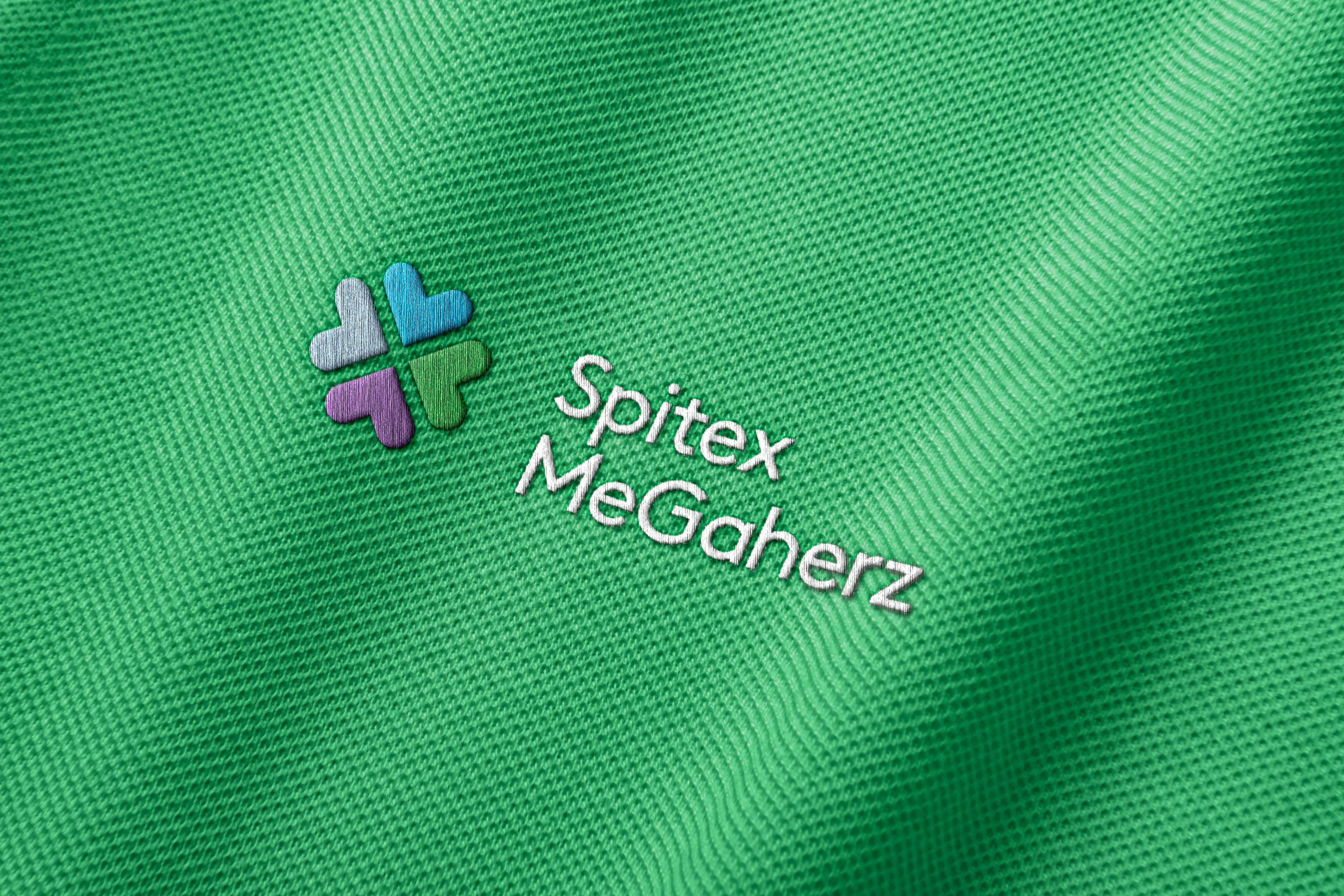 Embroidered Spitex MeGaherz mark on green fabric, macro detail